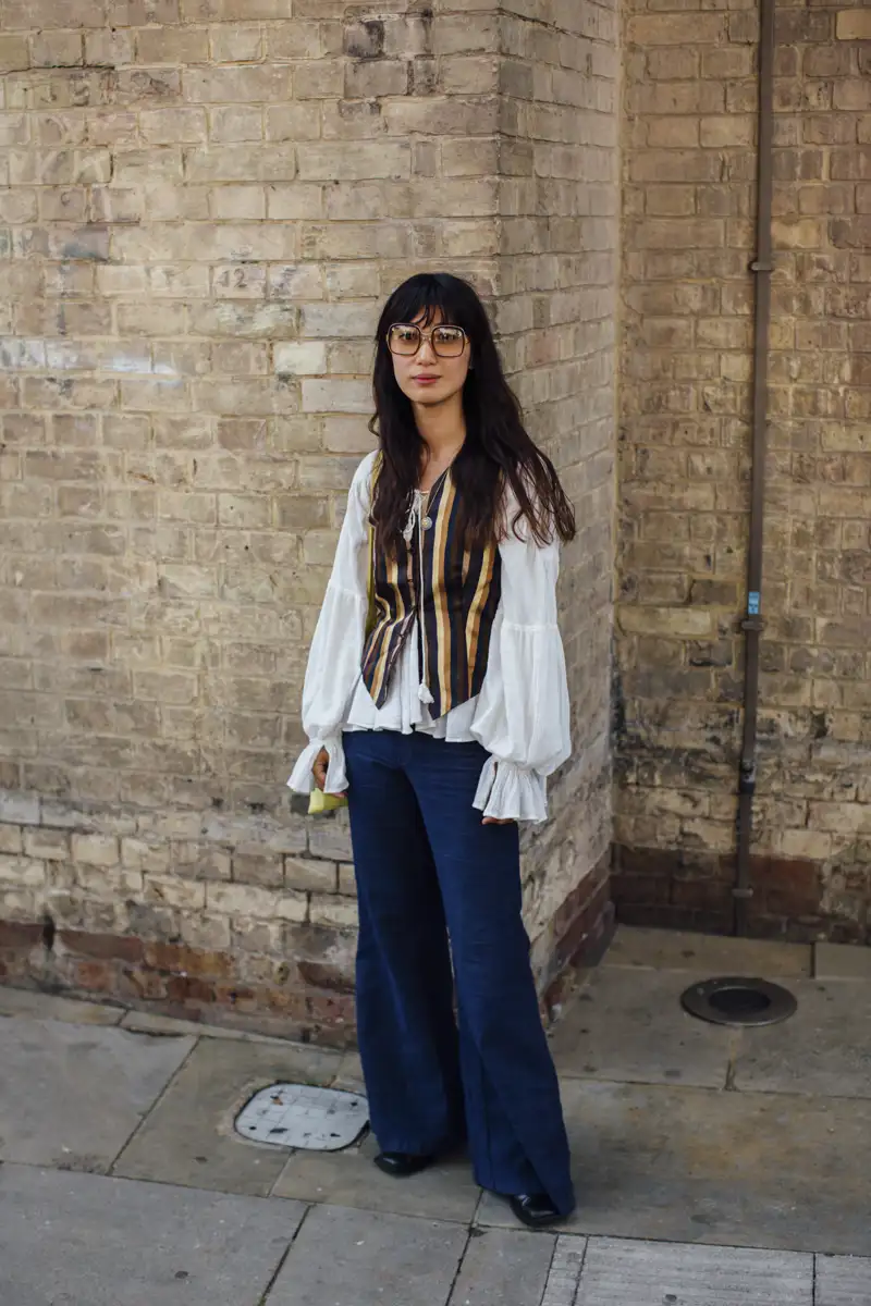 Cómo combinar un chaleco sin mangas en otoño: Con camisa romántica