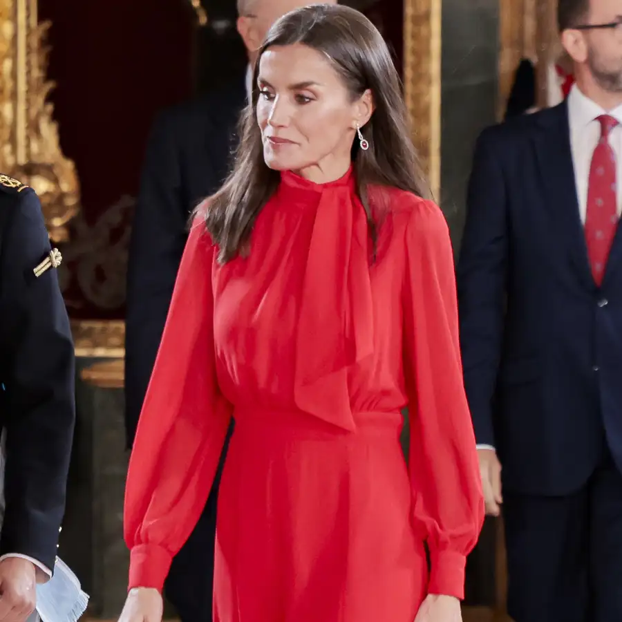 La reina Letizia, impecable, con vestido rojo España y gabardina beige con clon en Zara en un Día de la Hispanidad protagonizado por la lluvia