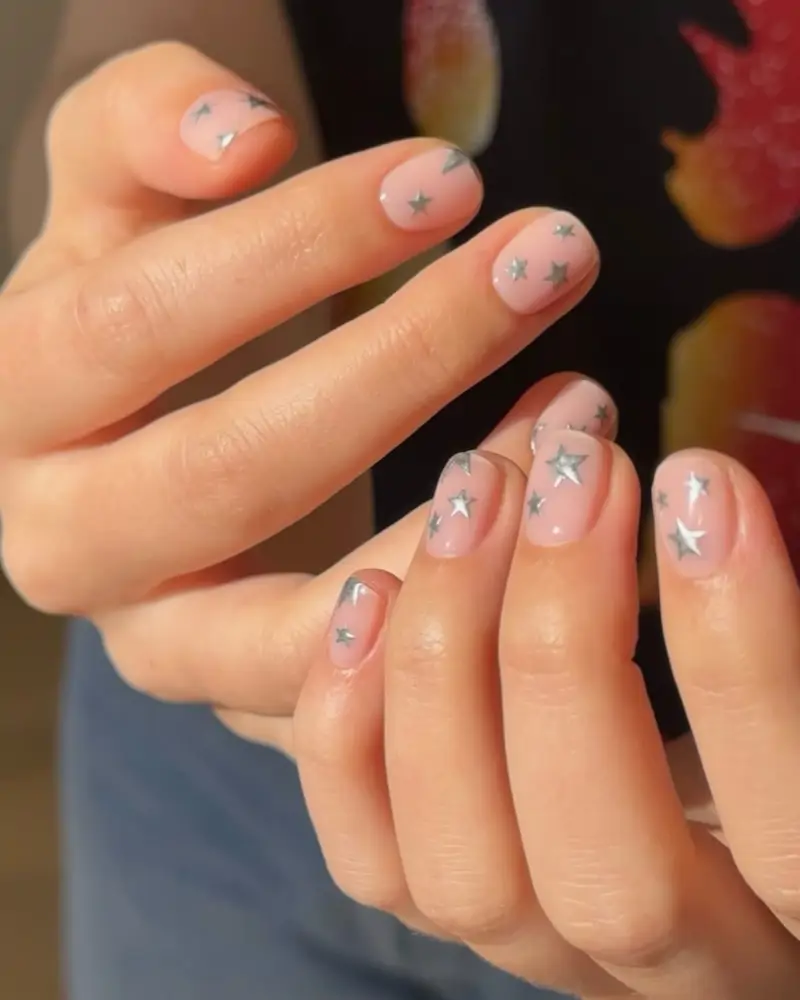 diseños de uñas con los colores de verano 2025 Con estrellas plateadas