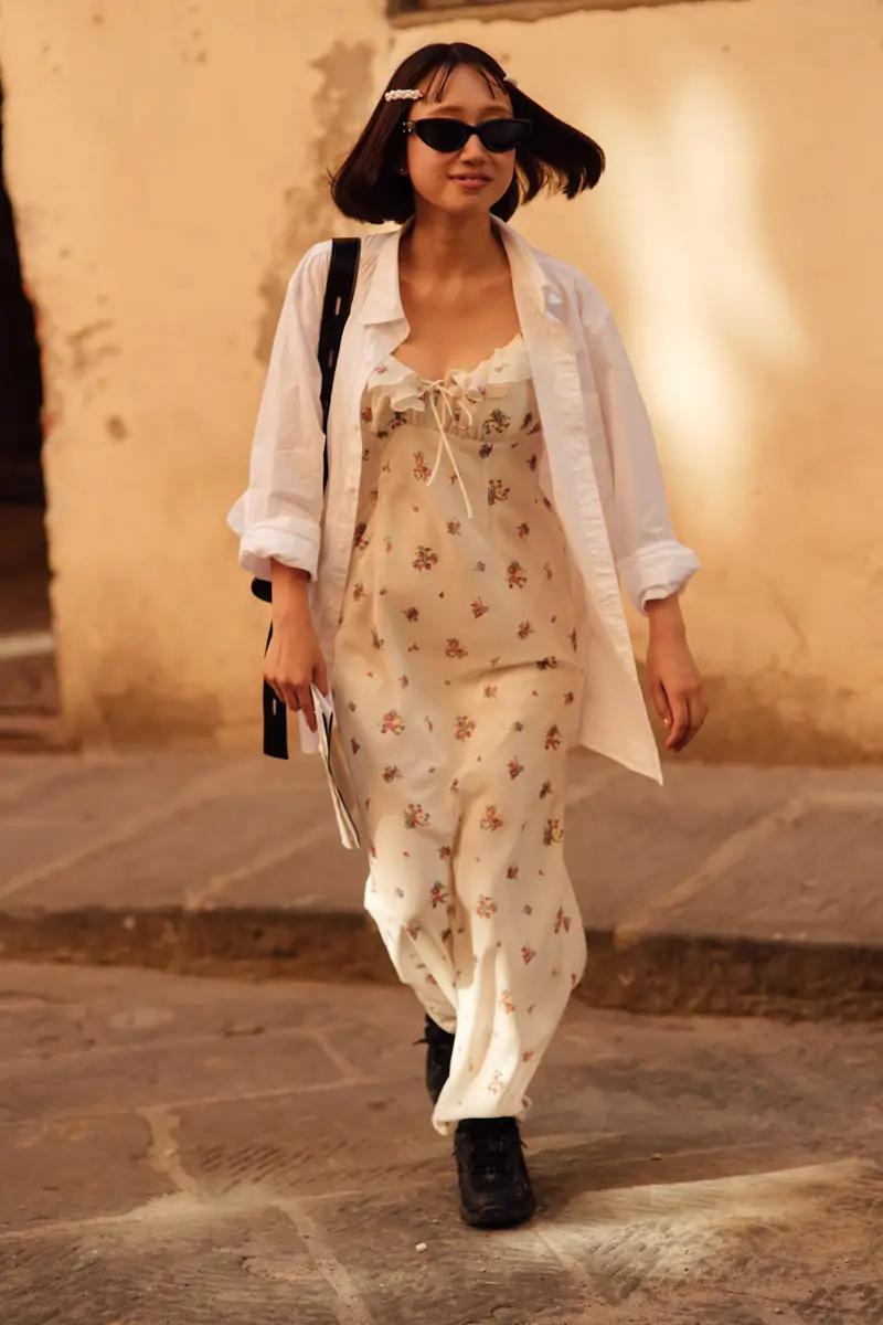 Robe fleurie portée avec une chemise blanche ouverte